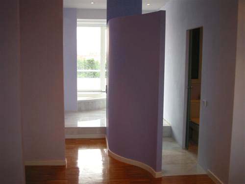 foto pasillo con  Pared curvada separando el lavabo permitiendo la entrada de luz natural a toda la habitación